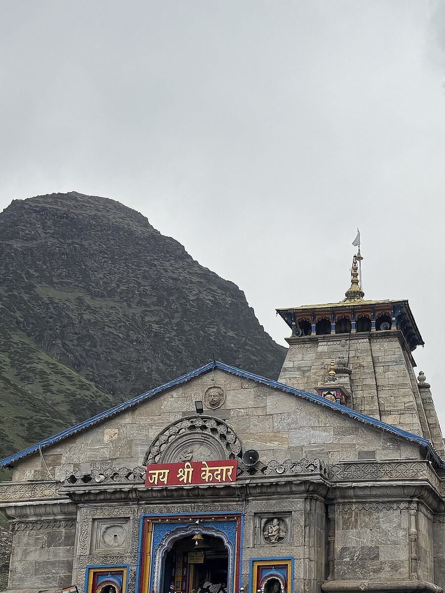 Kedarnath temple with the mountain wall rising behind it